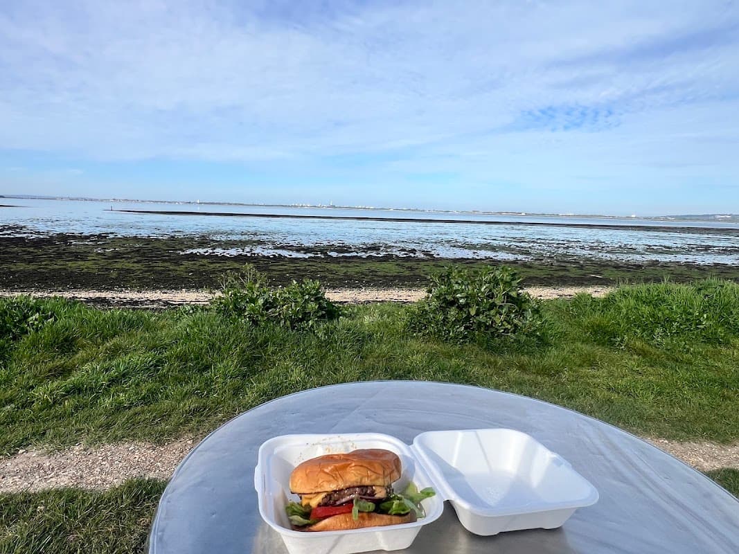 A takeaway burger box on a table overlooking the beach at Hayling Billy Bites, Hayling Island
